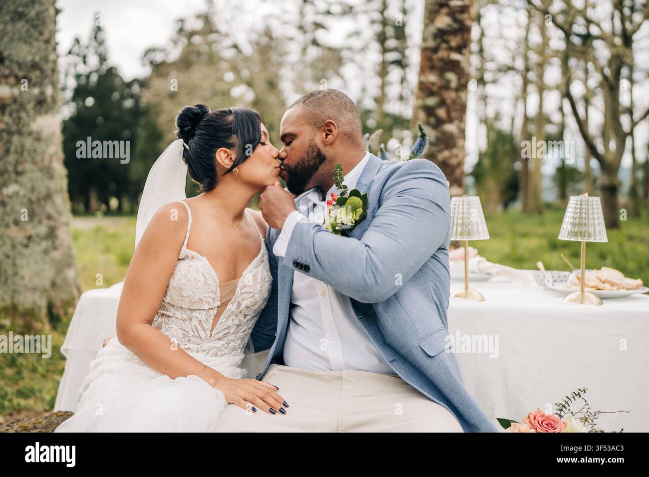 Newlywed couple share a romantic kiss outdoors Stock Photo
