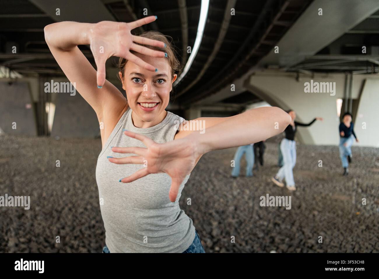 Woman smiles framing face with hands while dancing Stock Photo