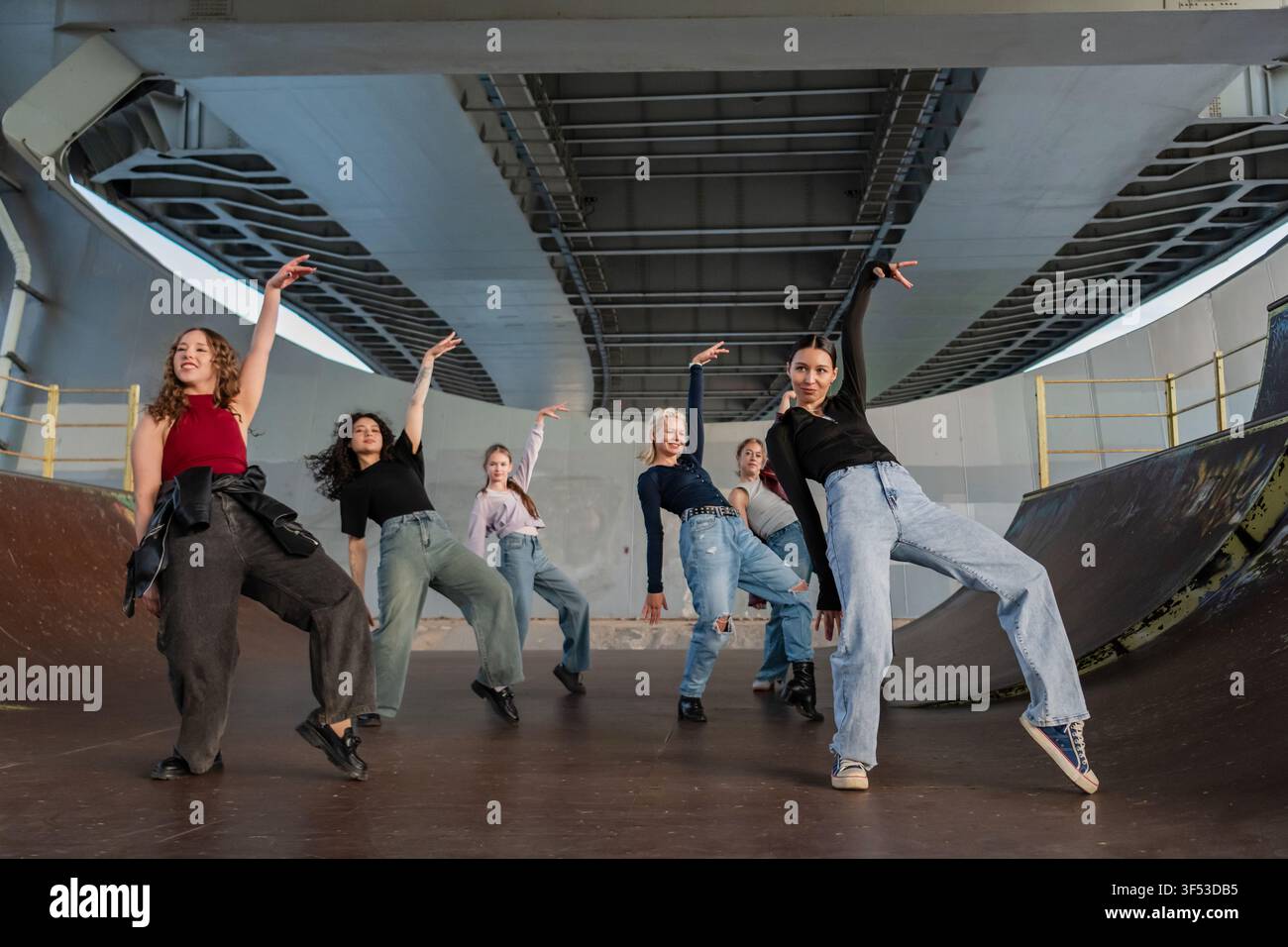 Young female dance crew striking a pose under a bridge Stock Photo