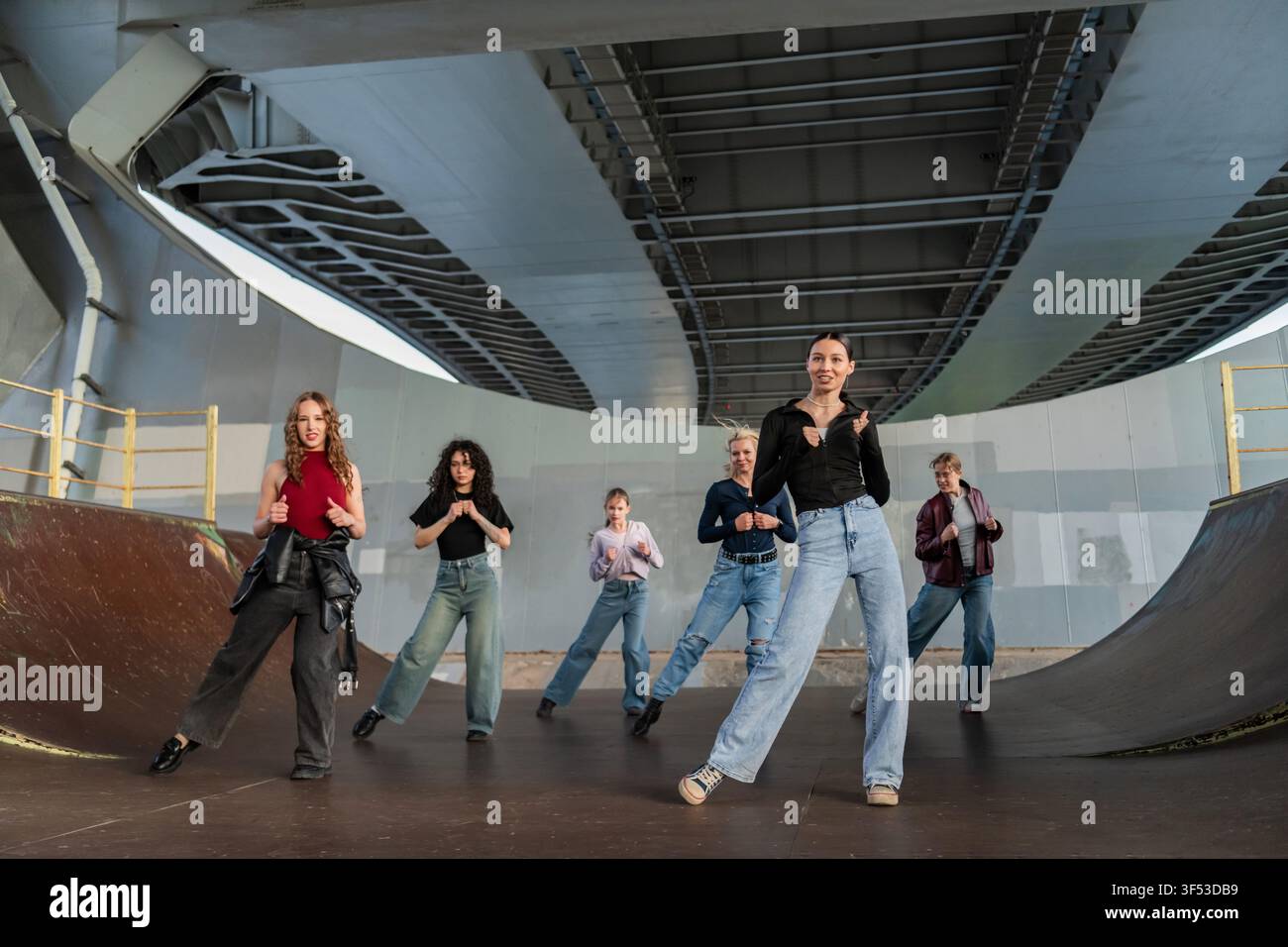 Young dance crew practicing routine under a bridge Stock Photo