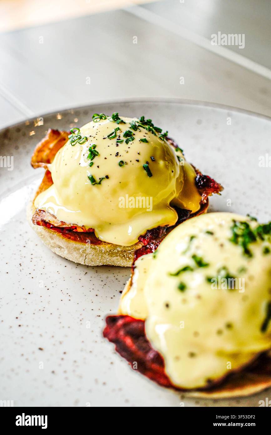 Gourmet eggs benedict with bacon and chives Stock Photo