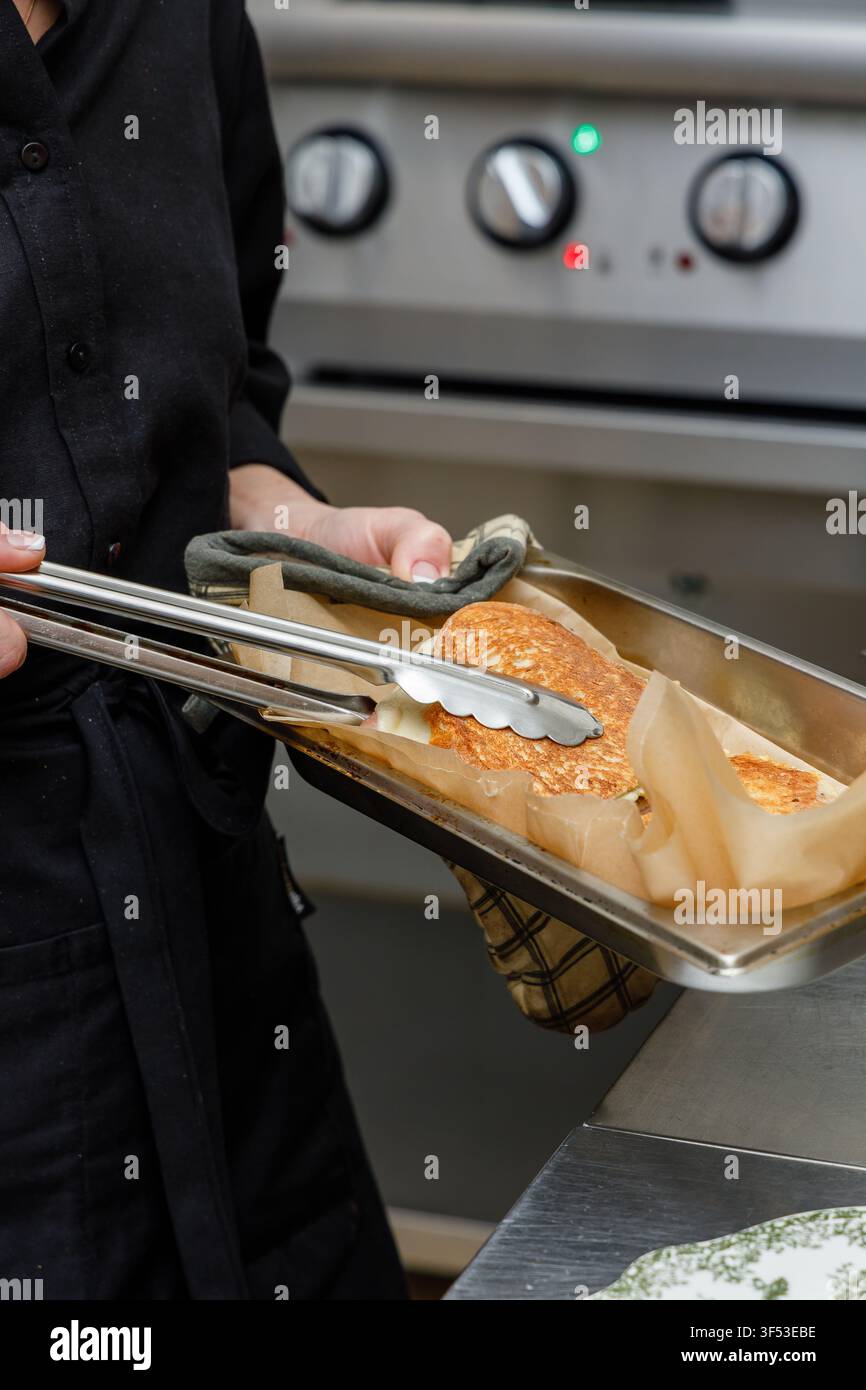 A female chef is preparing breakfasts in a restaurant. Stock Photo