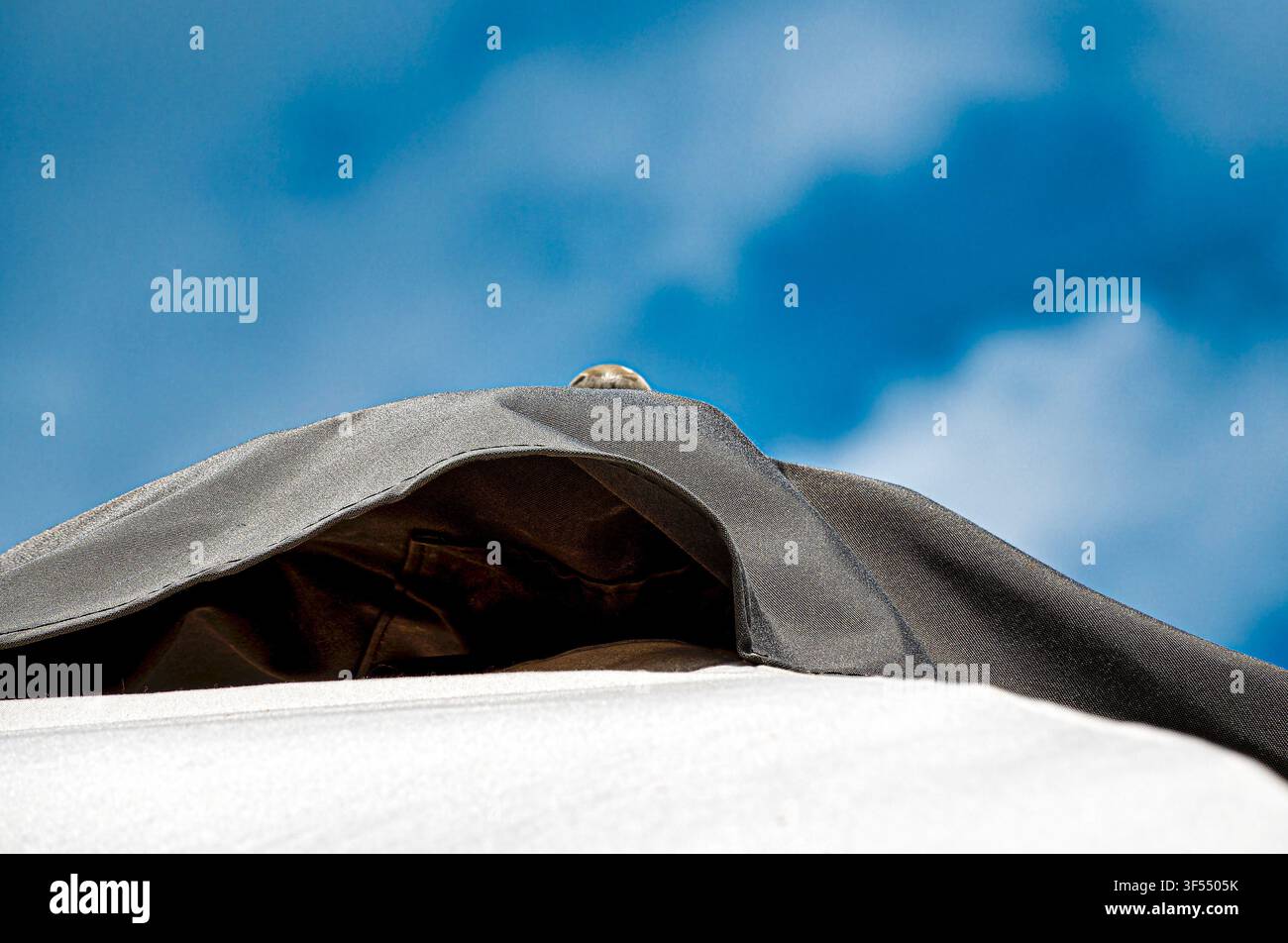 large beach umbrellas against a cloudy blue sky Stock Photo