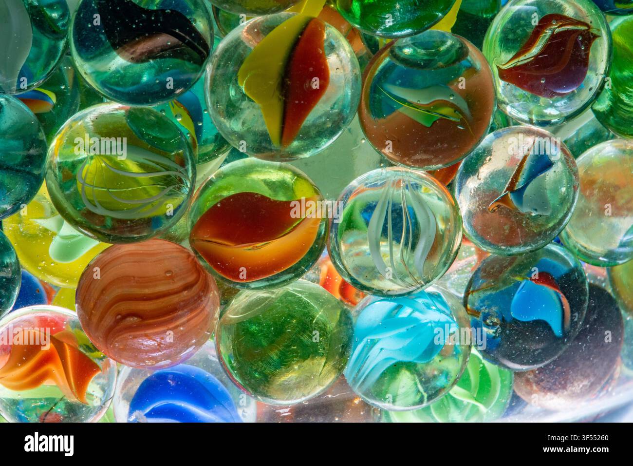 Glass marbles in various colors and patterns creating an abstract background Stock Photo