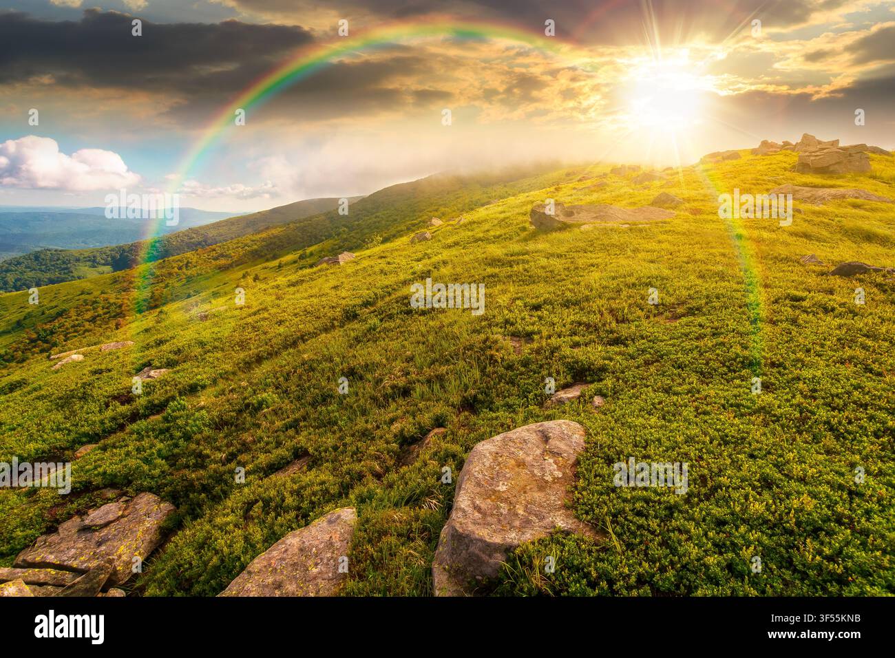 sunset over nature scenery with mountain under summer sky. alpine landscape of carpathian mountain with grassy slopes. low fluffy clouds on high altit Stock Photo