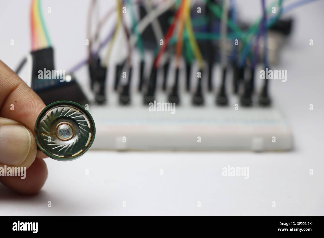 Plastic speaker connected to microcontroller on breadboard background Stock Photo