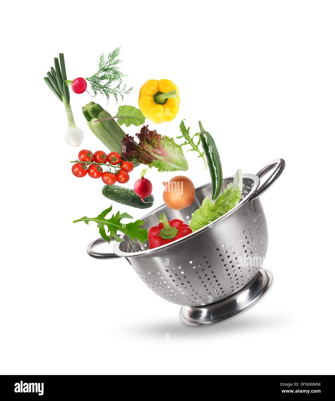 Fresh vegetables and colander in air on white background Stock Photo