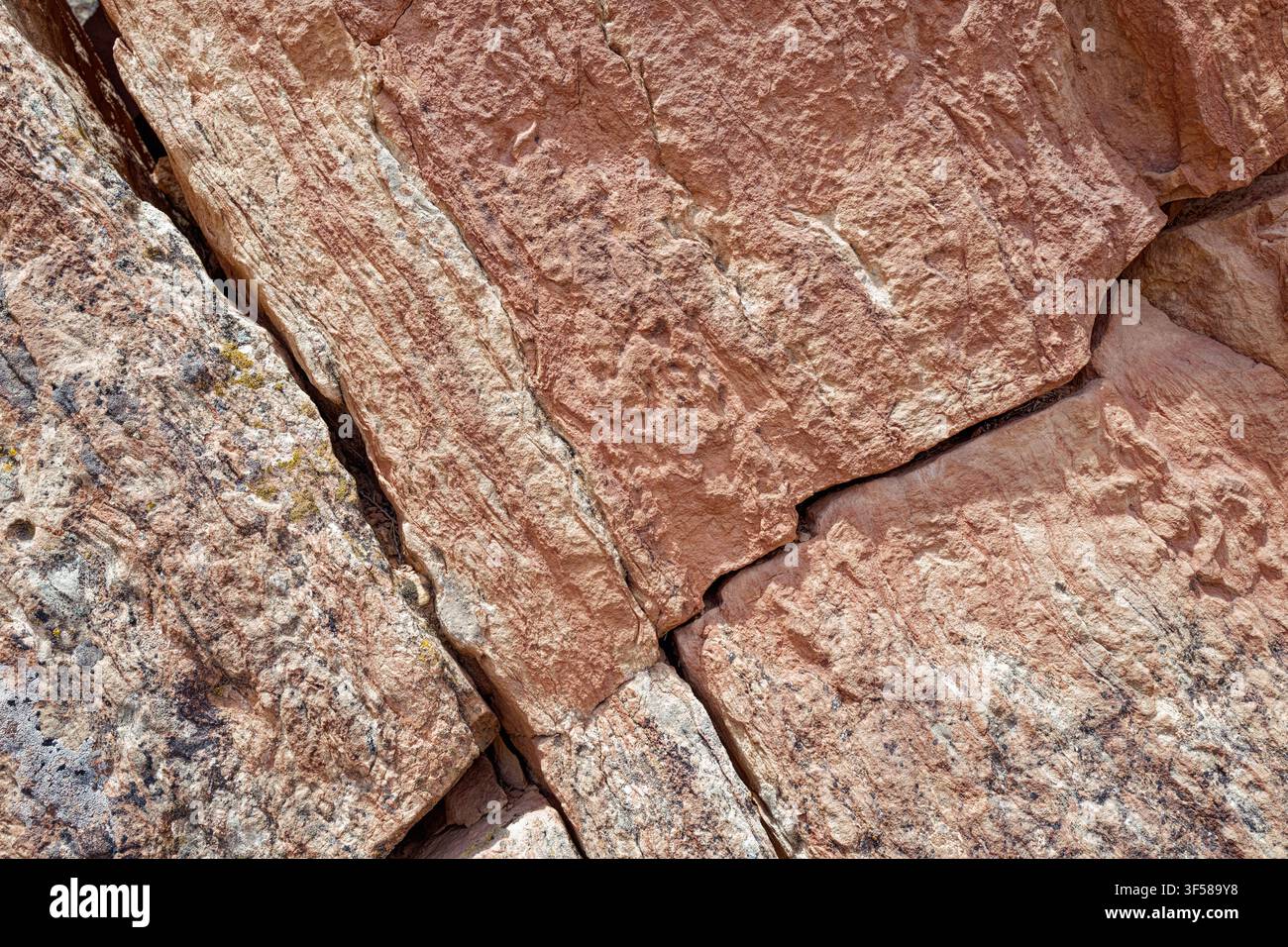 Detail of diagonal cracks in a reddish sandstone rock surface Stock Photo