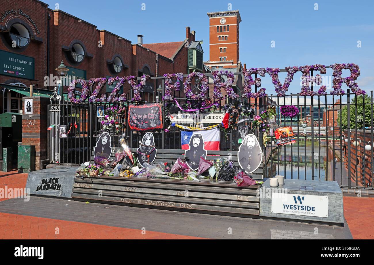 Flowers and fan tributes surround the Black Sabbath Bench in Birmingham after Ozzy Osbourne's death in 2025 - Ozzy Forever Stock Photo