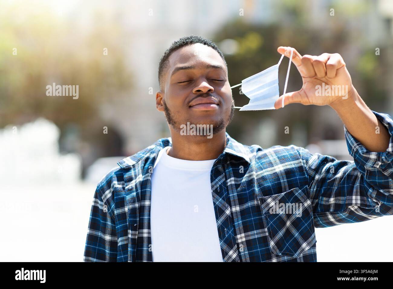 Portrait of afro man taking off mask and breathing Stock Photo
