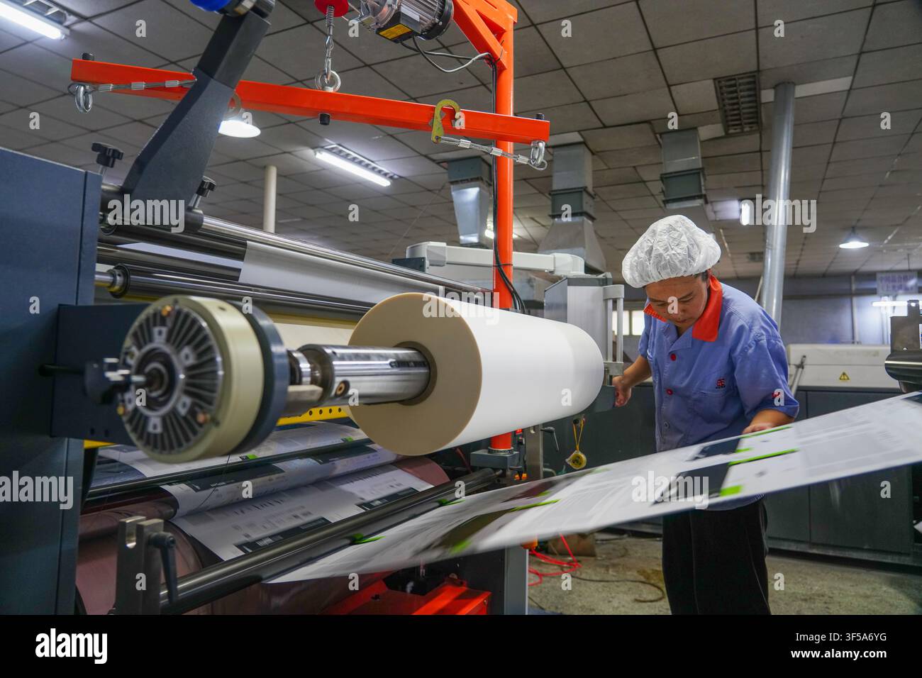 Luanan, China - July 30, 2026: Worker Debugging Printing Machine to Align Printed Boards Stock Photo