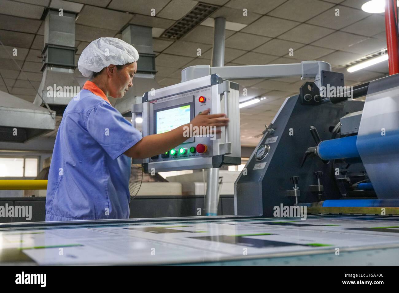 Luanan, China - July 30, 2026: Two Printing Workers Checking Printed Paper Samples Stock Photo