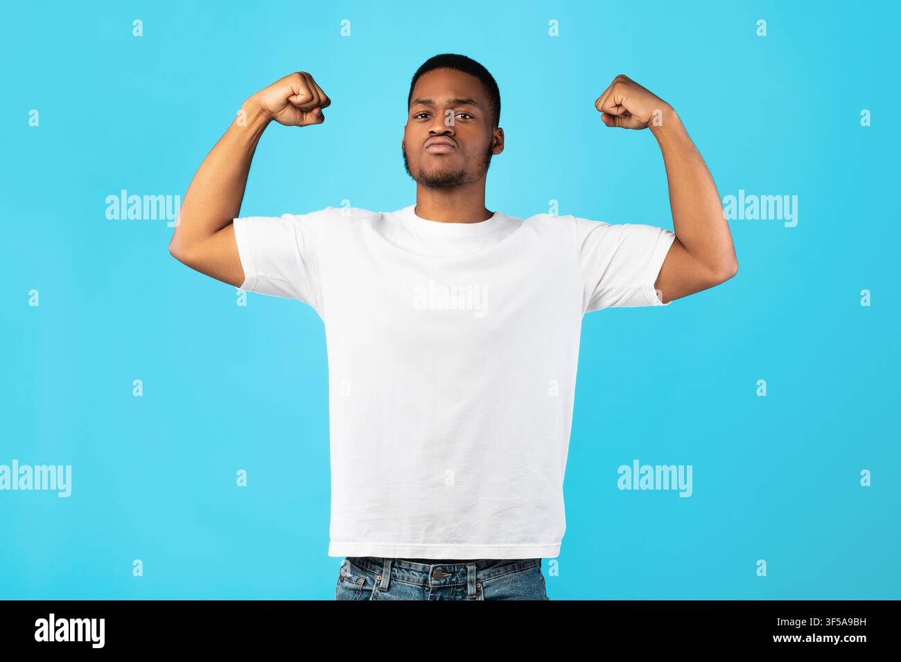 Strong Black Guy Showing Biceps Posing On Blue Background Stock Photo