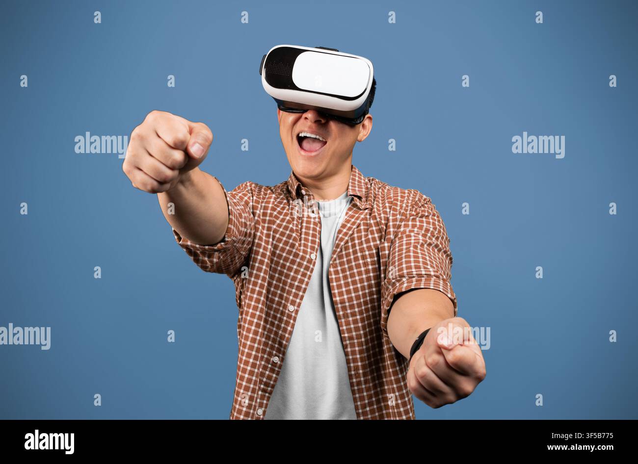 Excited Young Man With Vr Headset Engaging In Virtual Reality Experience, Studio Background Stock Photo