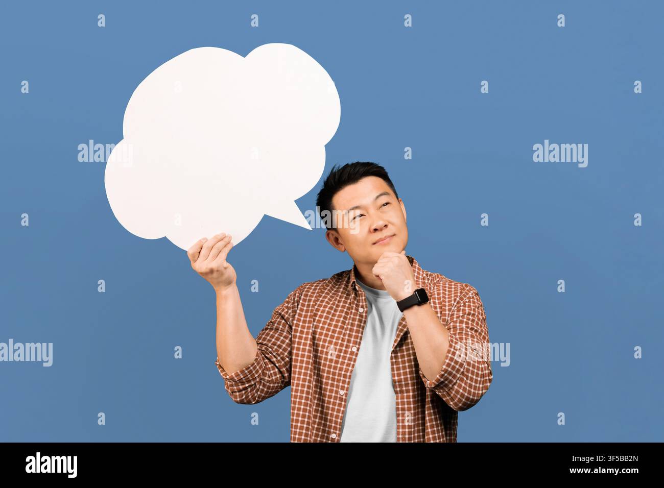 Thoughtful Asian Man Holding Speech Bubble And Thinking, Creative Concept Stock Photo