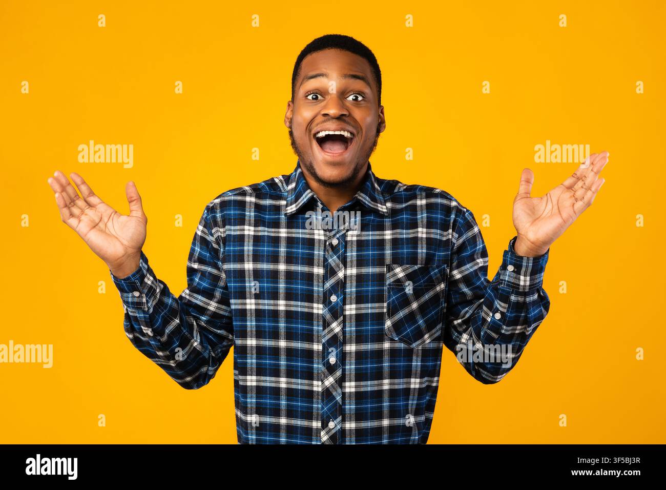 Surprised African Guy Posing With Opened Mouth Over Yellow Background Stock Photo
