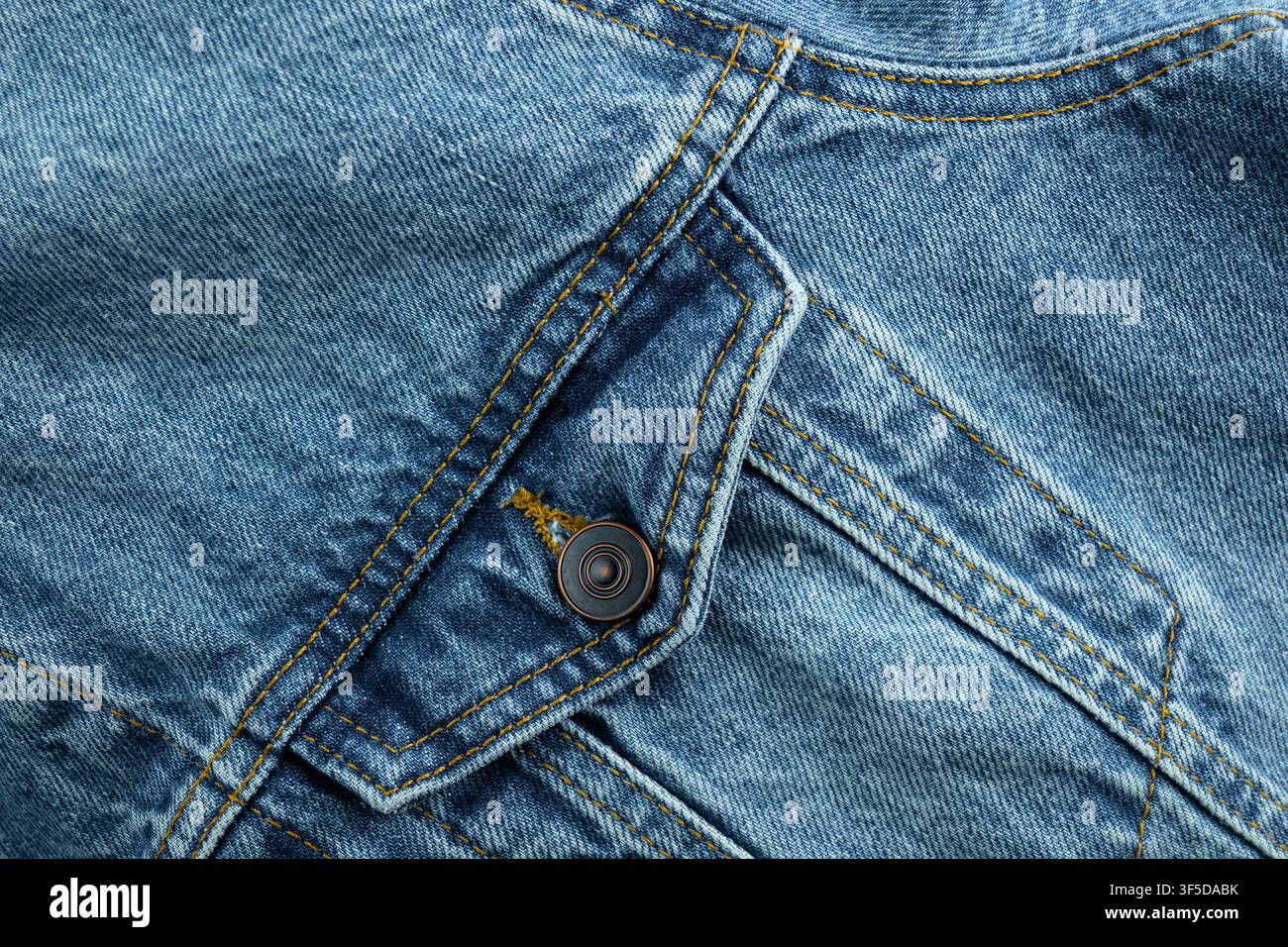 Blue denim fabric showing texture, stitching, pockets, and a button Stock Photo