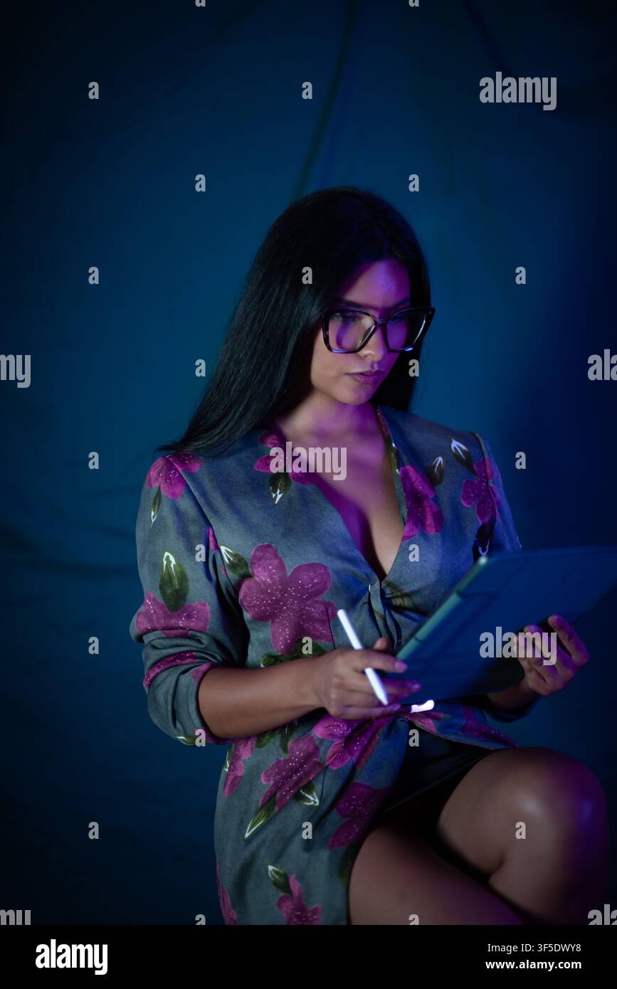 Woman creating digital art on tablet using stylus Stock Photo