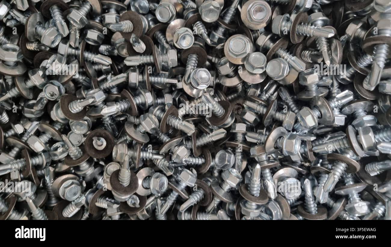 Texture of small bolts and nuts in bulk. Stock Photo