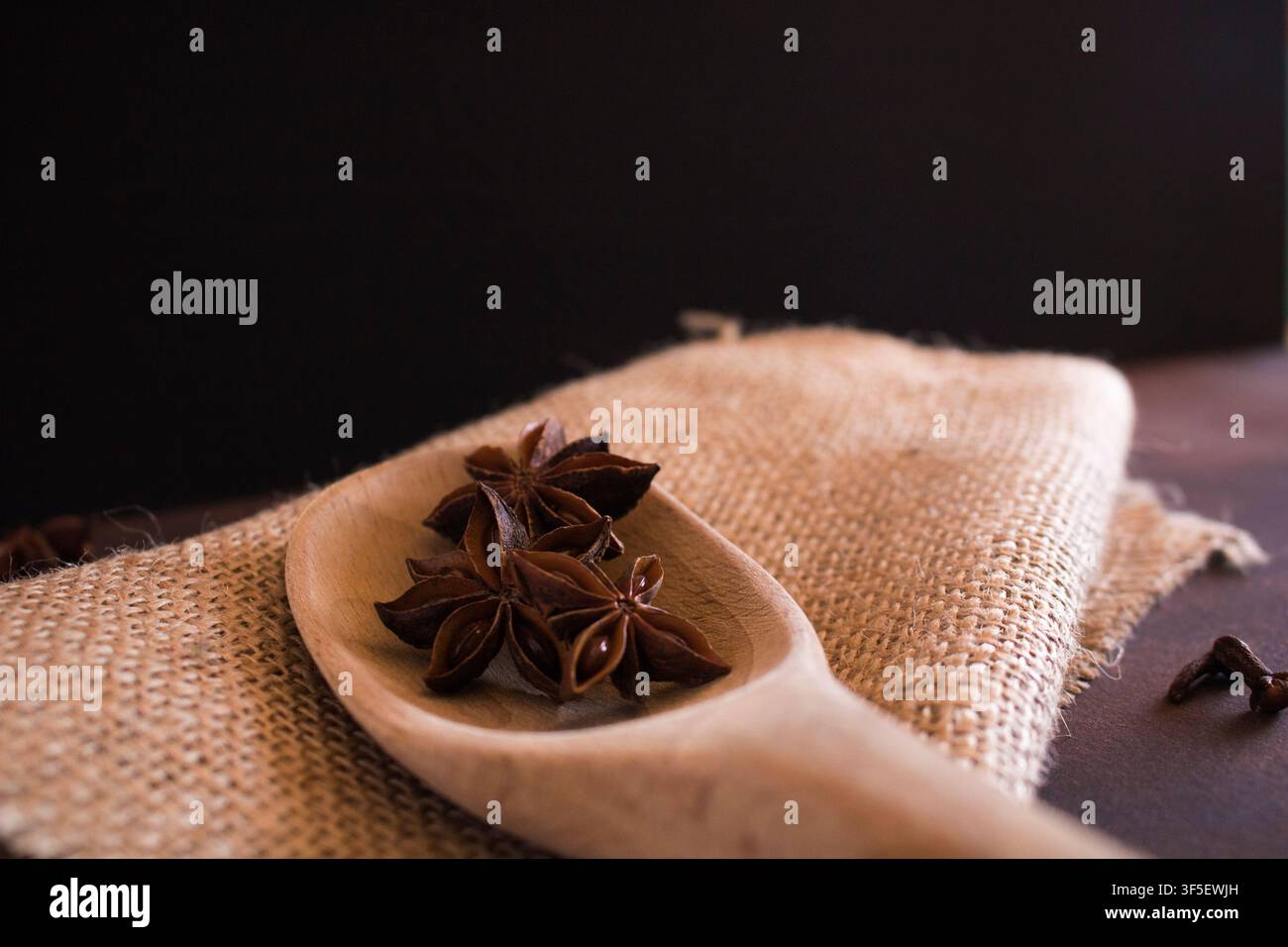 star anise in a spoon on a sackcloth Stock Photo