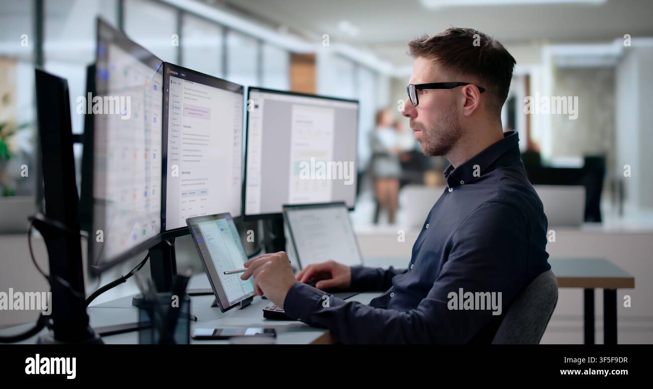 Young Software Engineer Works On Laptop Creating AI-powered Knowledge System. Stock Photo