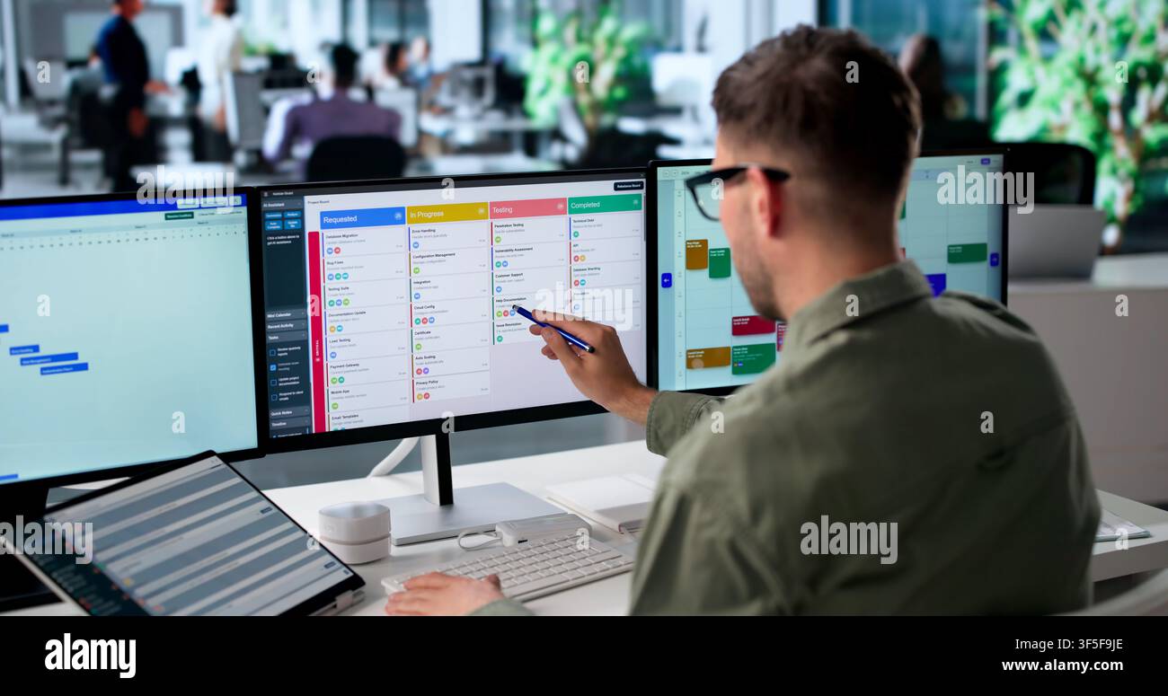 Agile Project Manager Updates Digital Scrum Board Tasks Using Laptop Screen. Stock Photo