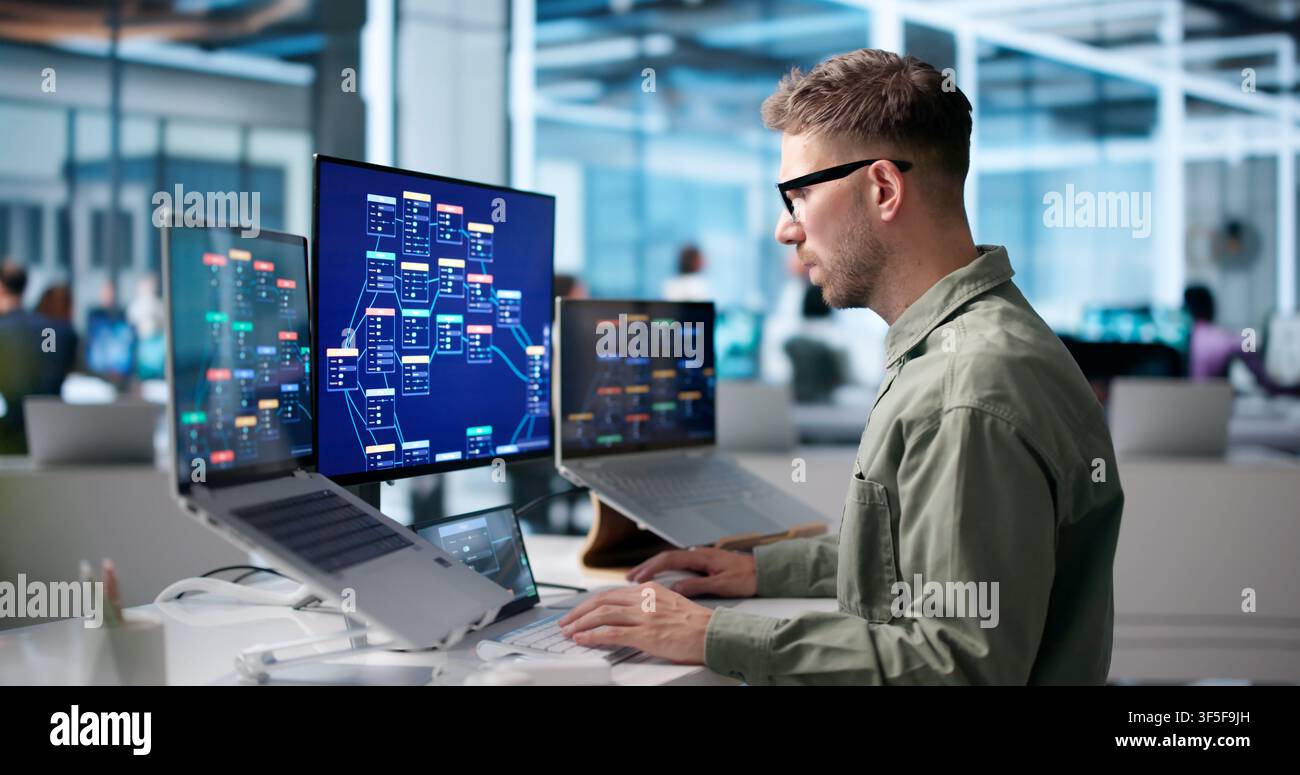 Young Male Software Developer Uses Low Code Platform On Laptop. Stock Photo