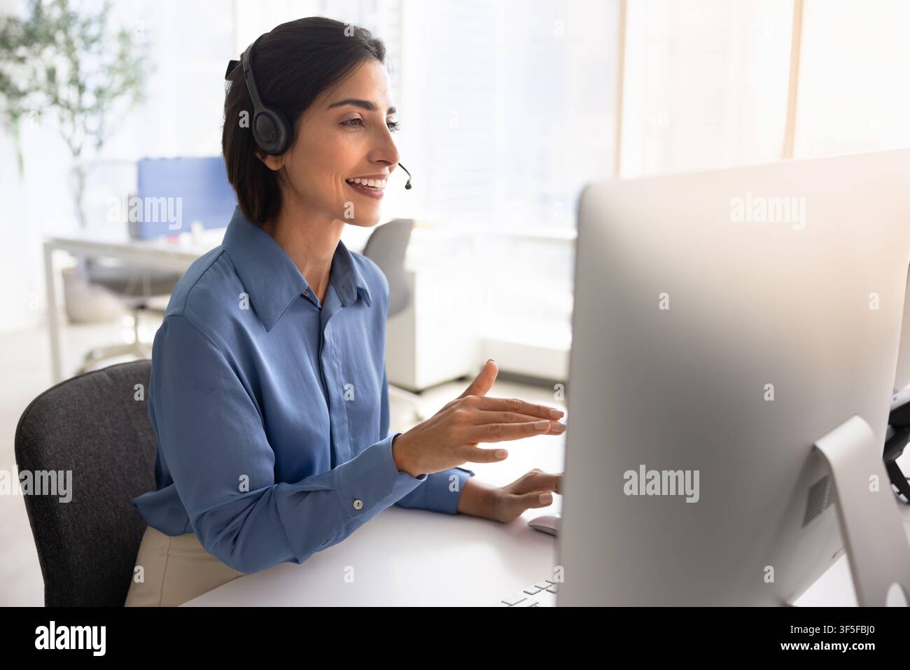 Technical support operator in headset talks with client Stock Photo