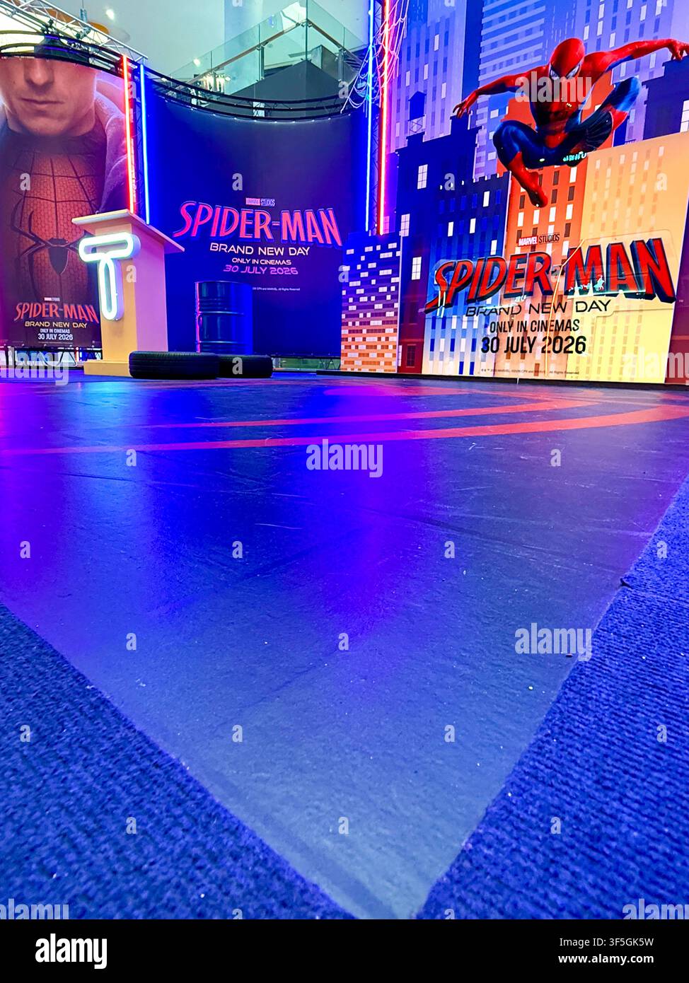 A colorful promotional display for the Spider-Man Brand New Day movie with neon lights and cityscape backdrop. - Smartphone Captured Stock Image