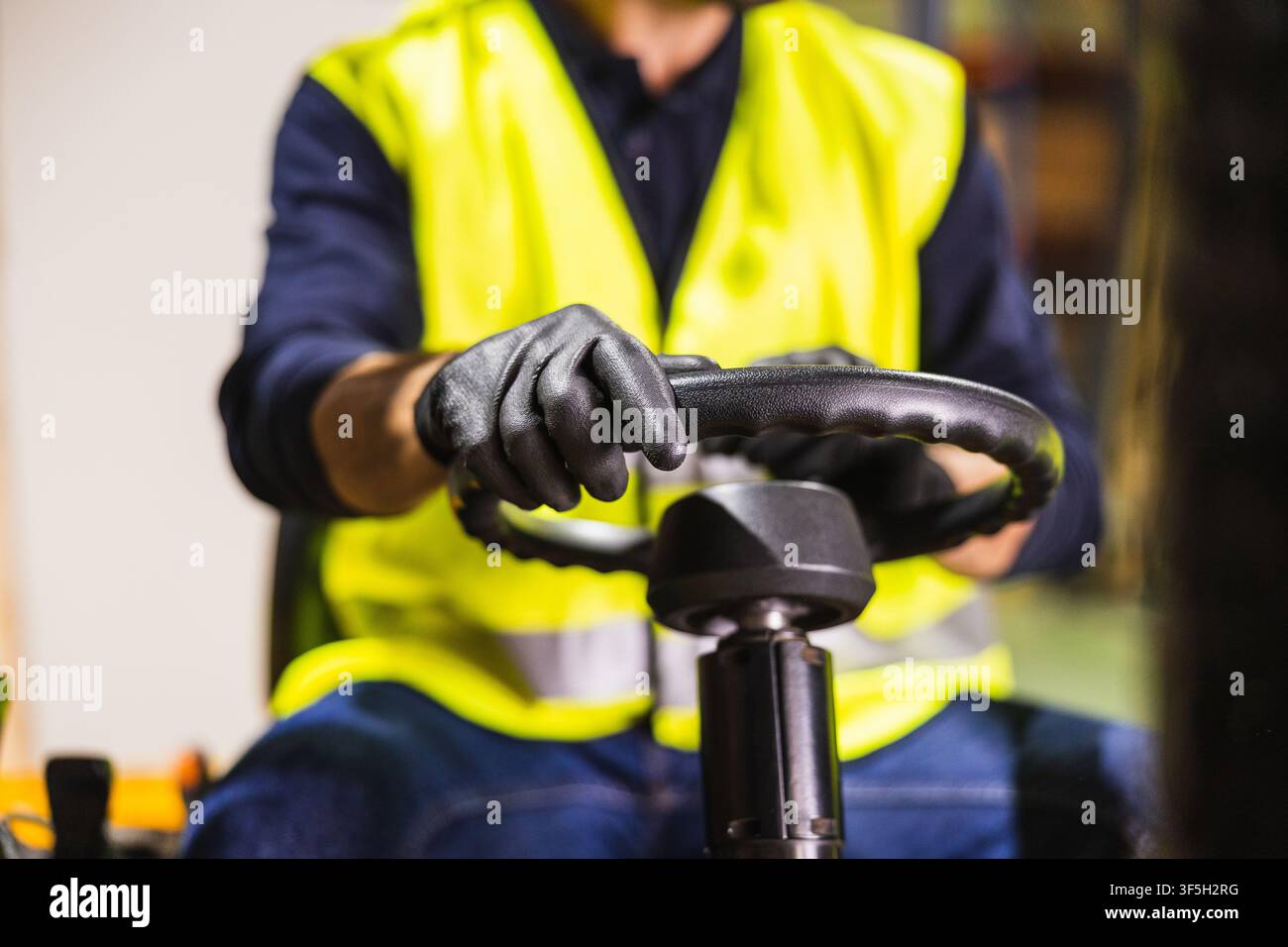 Worker operating forklift in warehouse or lumberyard Stock Photo