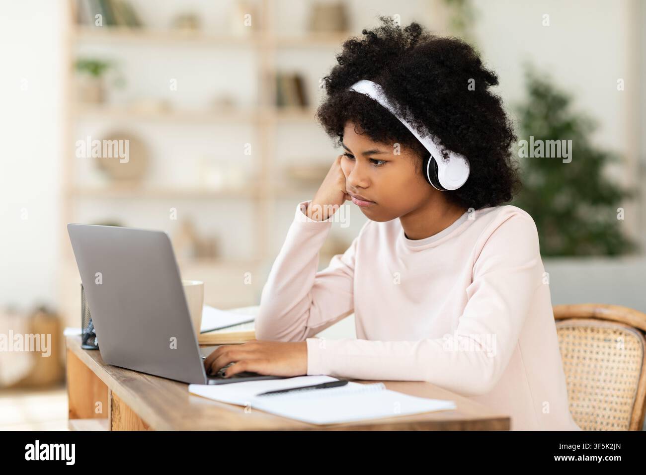 Sad Black Girl Sitting At Laptop Computer Learning From Home Stock Photo