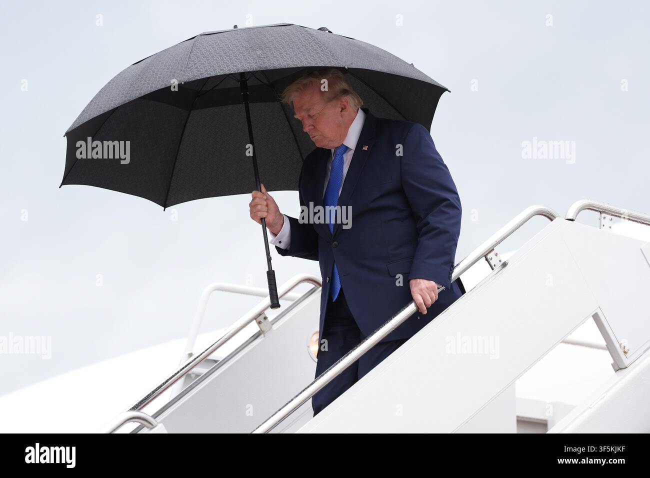 President Donald Trump carries an umbrella as he exits Air Force One at Joint Base Andrews, Md., Sunday, Aug. 2, 2026, on return to Washington. (AP Photo/Jacquelyn Martin) Stock Photo
