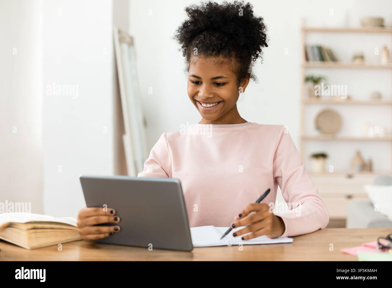 Secondary School Student Girl Studying Using Digital Tablet At Home Stock Photo