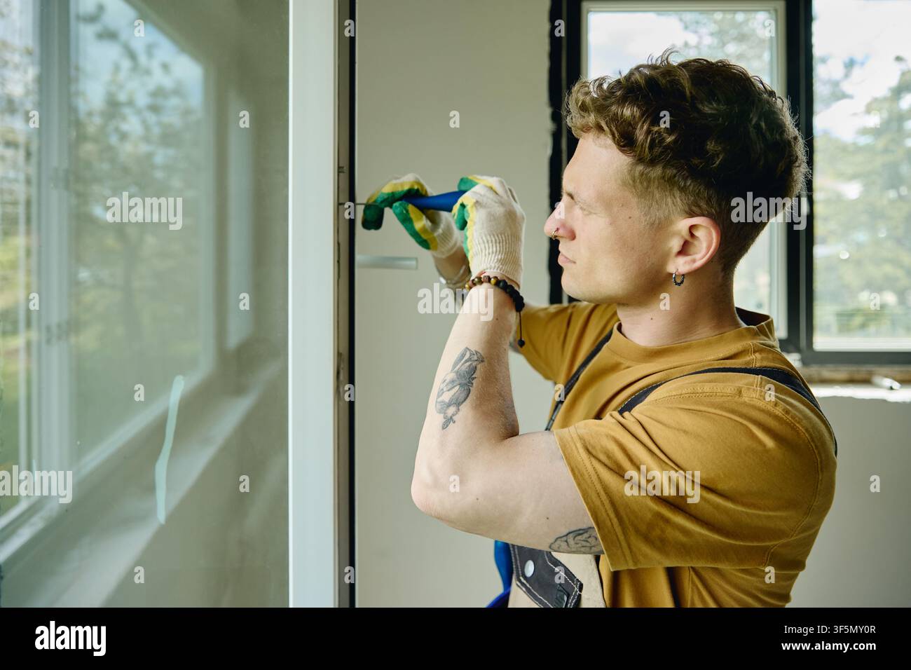 Man Installing Window Frame during House Renovation Stock Photo