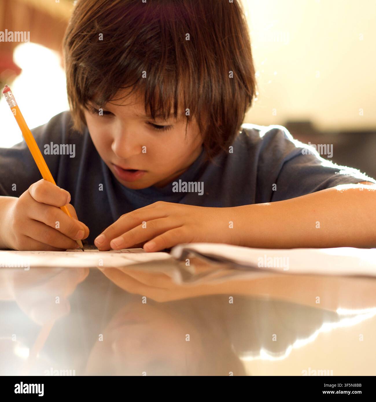 7-year old first grader doing his homework. Stock Photo