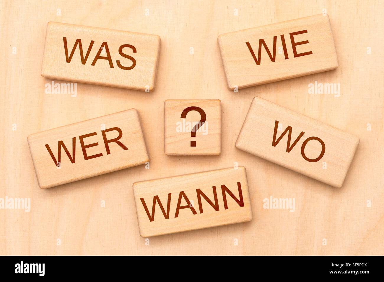Grundfragen im Journalismus Die journalistischen Grundfragen sind gedruckt auf Holzwürfel mit Fragezeichen - FOTOMONTAGE - NUR FÜR REDAKTIONELLE VERWENDUNG - *** Fundamental Questions in Journalism The fundamental questions of journalism are printed on wooden cubes with question marks. PHOTO MONTAGE FOR EDITORIAL USE ONLY Stock Photo