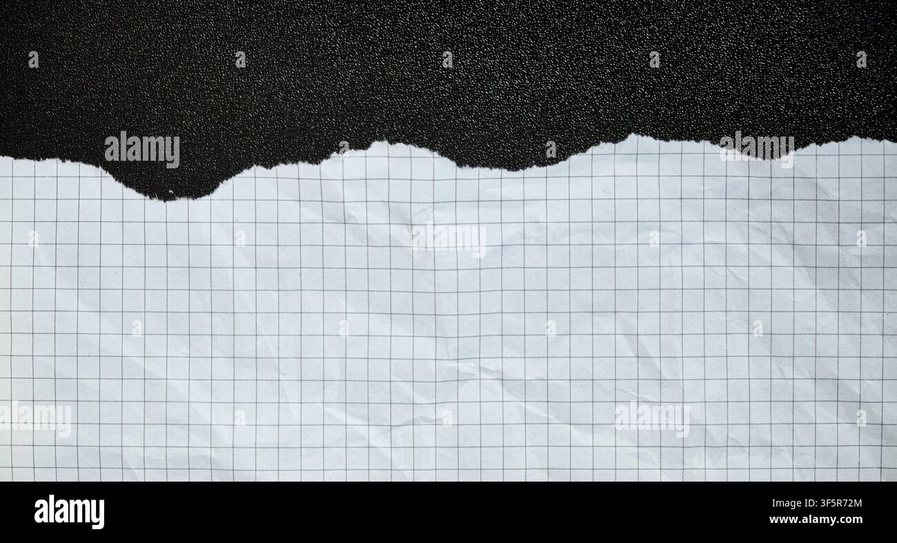 Ripped piece of squared paper on a black background, white crumpled texture, isolated centered composition, abstract banner. Stock Photo