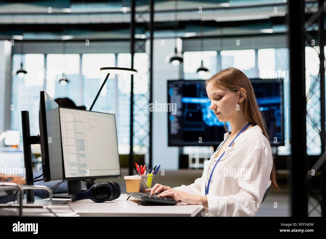 Female engineer developing applications using PC, integrating AI in office systems. Worker doing internship in tech startup debugging applications using artificial intelligence Stock Photo