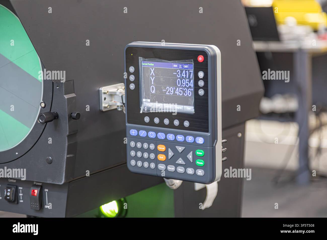 Industrial digital control panel with measurement system closeup, featuring small screen displaying coordinates and angles, function keys, numeric key Stock Photo