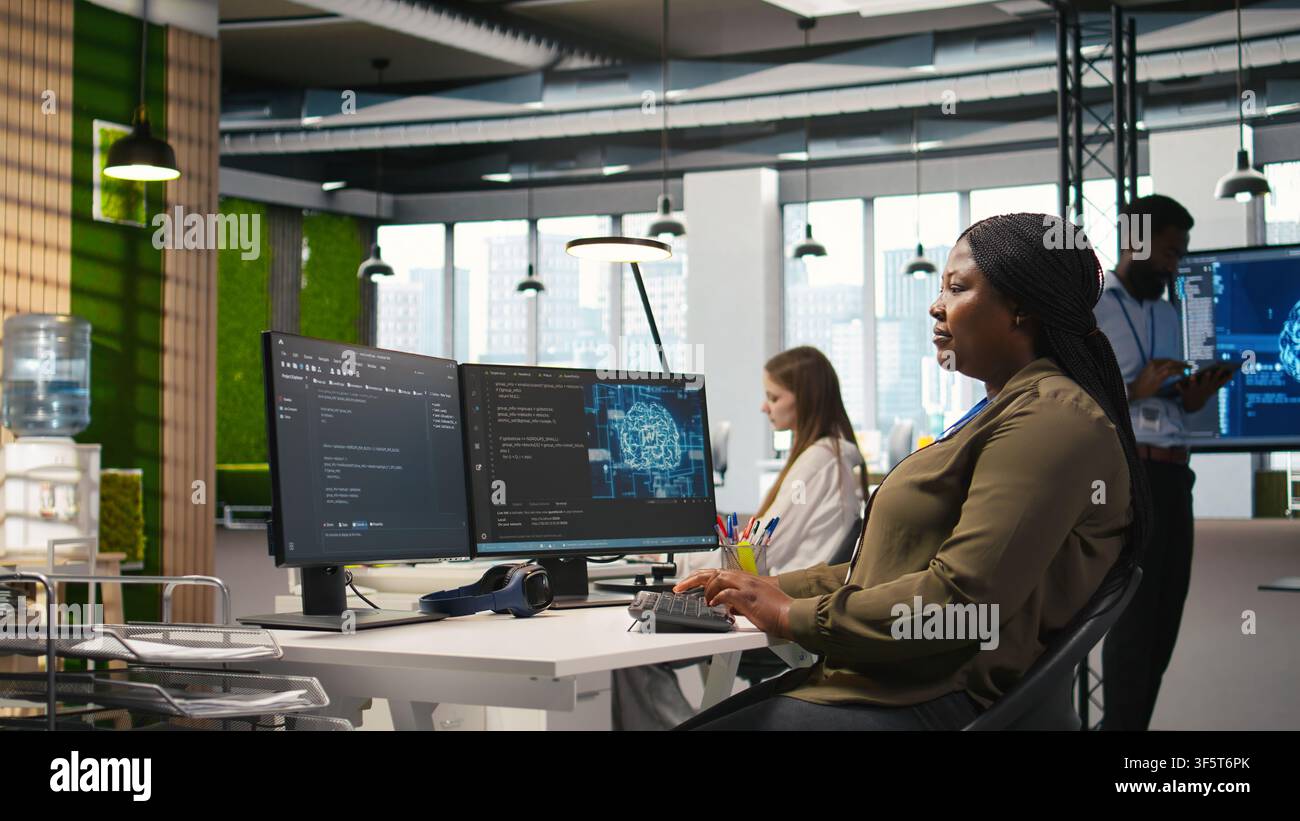 Female admin using AI neural networks tech on computer to optimize performance and forecast issues. Woman in office training artificial intelligence deep learning models using PC, camera A Stock Photo