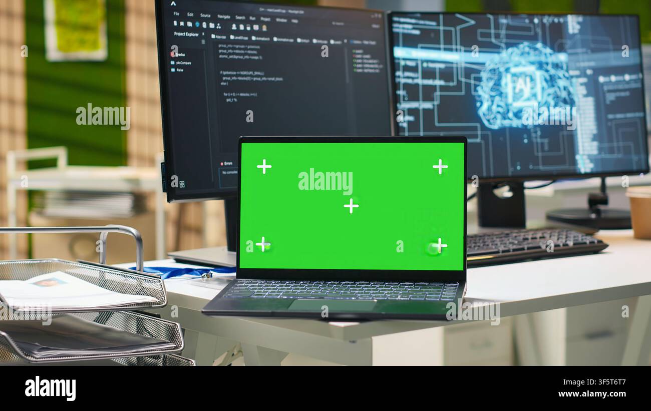 Green screen laptop and AI algorithms running on computer monitors in empty startup workspace deploying machine learning models. Mockup notebook and artificial intelligence coding platform in office Stock Photo