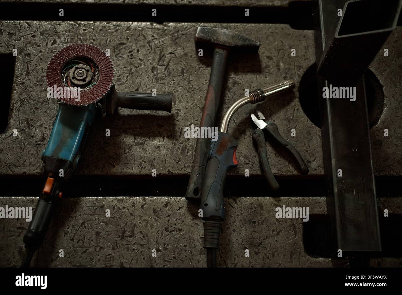 Industrial Welding and Grinding Tools Lying on Metal Workbench Stock Photo