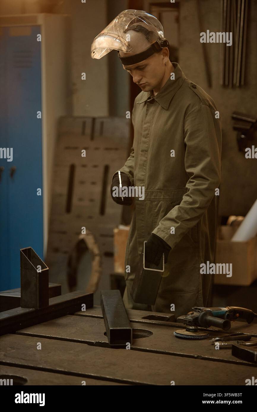 Male Welder in Protective Gear Working with Metal in Workshop Stock Photo