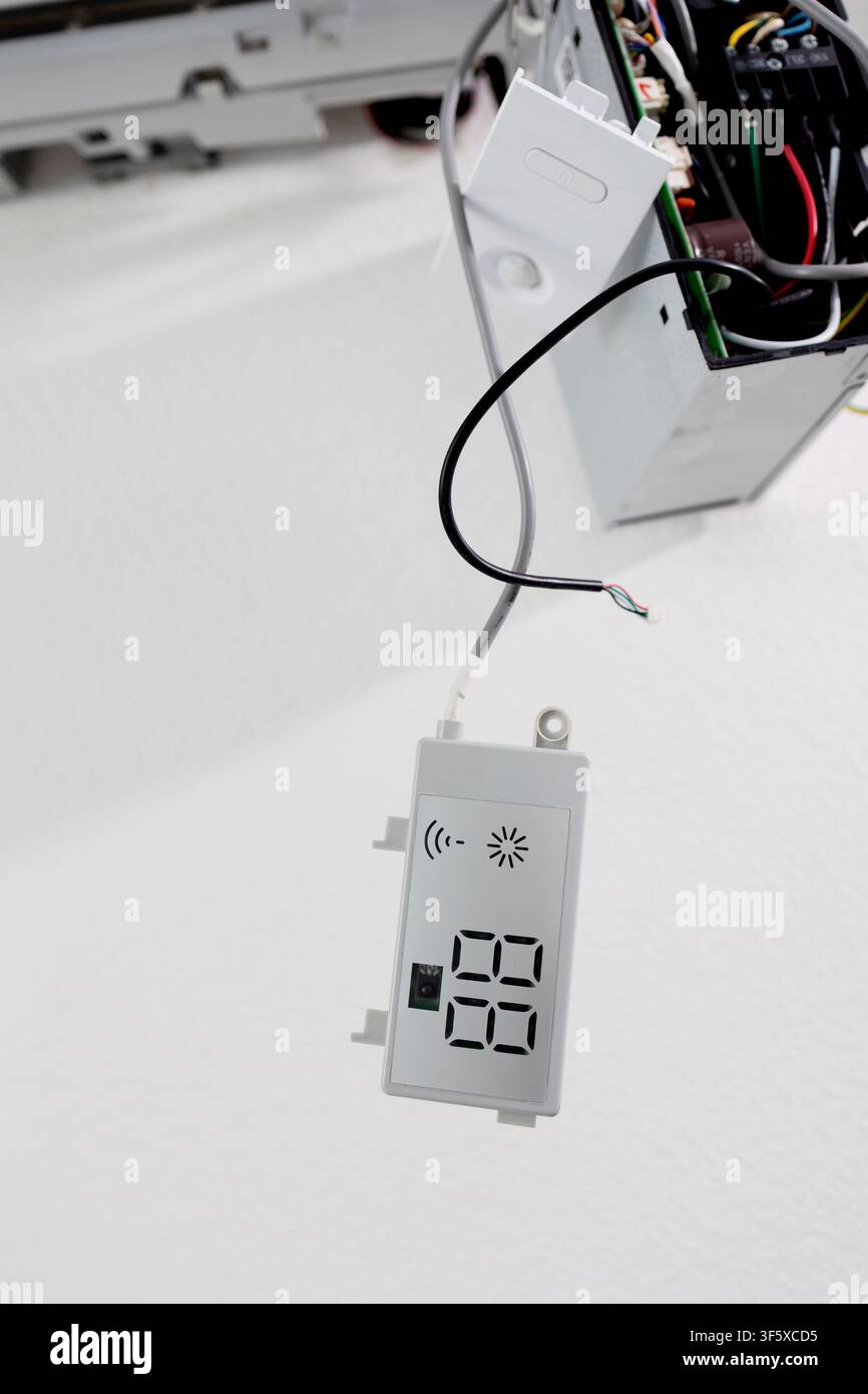 Technician repairing air conditioner internal display module. HVAC system maintenance and electronics Stock Photo