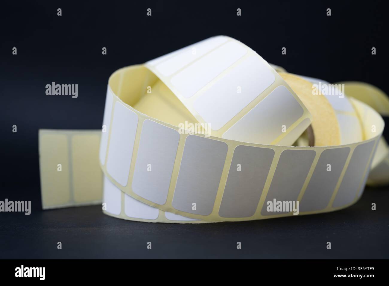 Rolls of blank white adhesive labels isolated on white for direct thermal and thermal transfer printing, packaging, pricing and retail use. Stock Photo