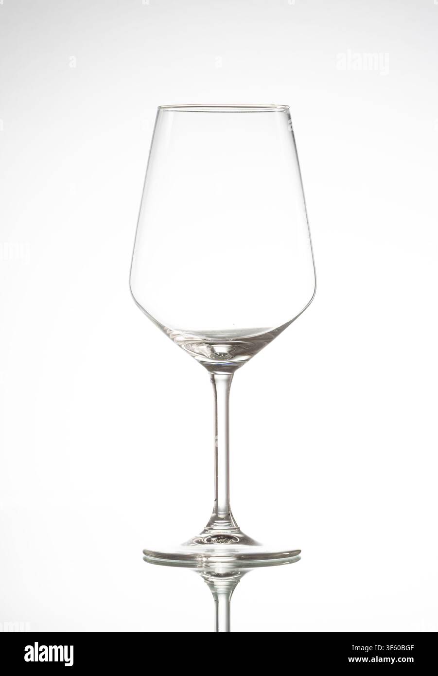 Empty crystal stemware glass reflecting on a clean white background Stock Photo