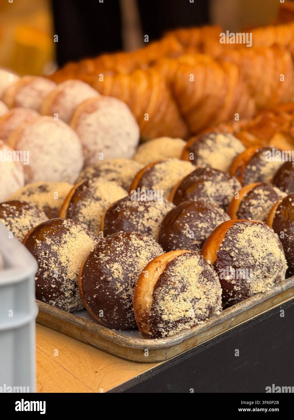 Assorted pastries including chocolate-covered donuts from a bakery with a tempting display. Mobile photo Stock Photo