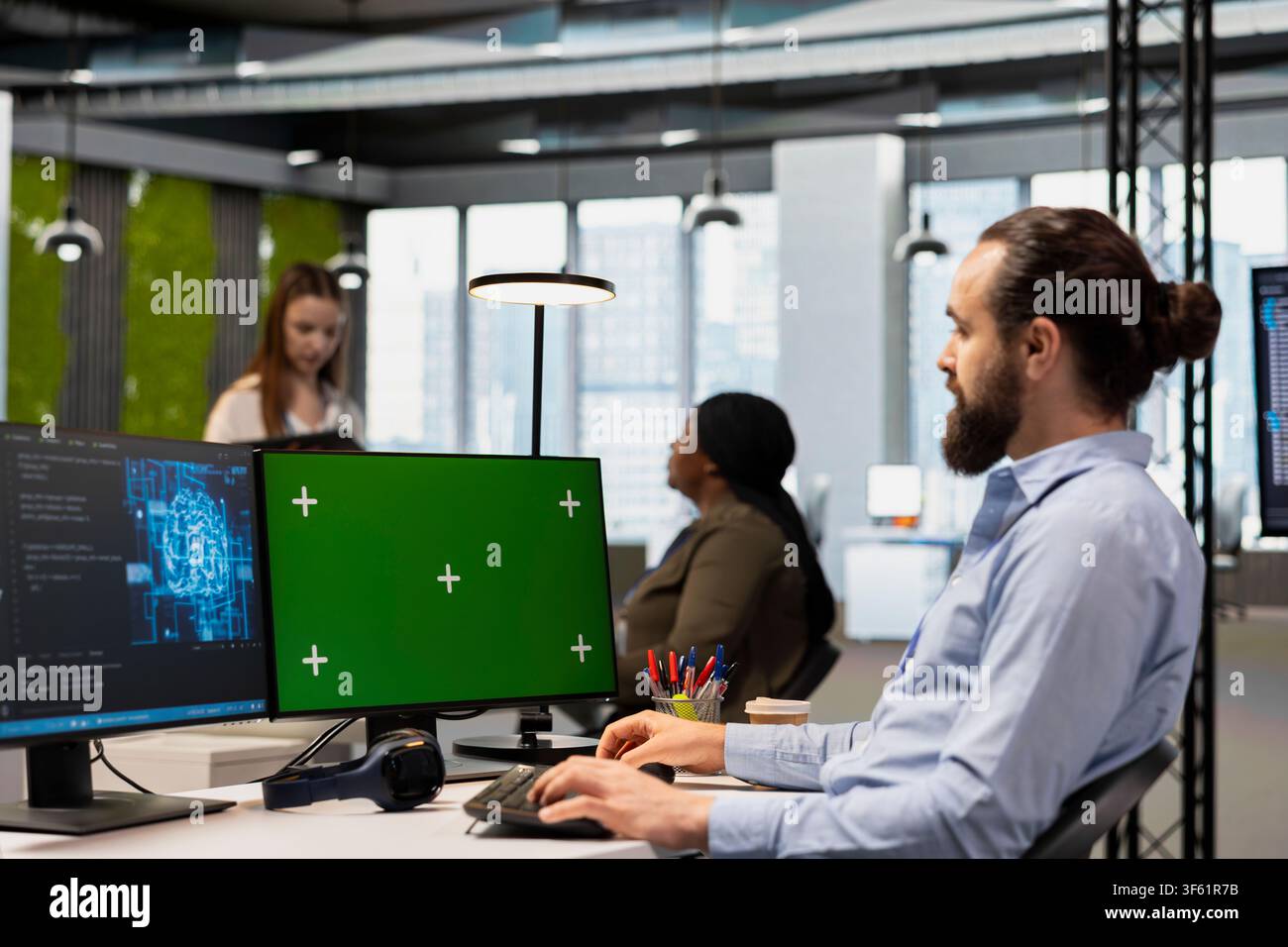 Programmer in office using AI automation scripts on green screen computer to reduce repetitive coding tasks. IT expert using artificial intelligence technology on chroma key PC Stock Photo