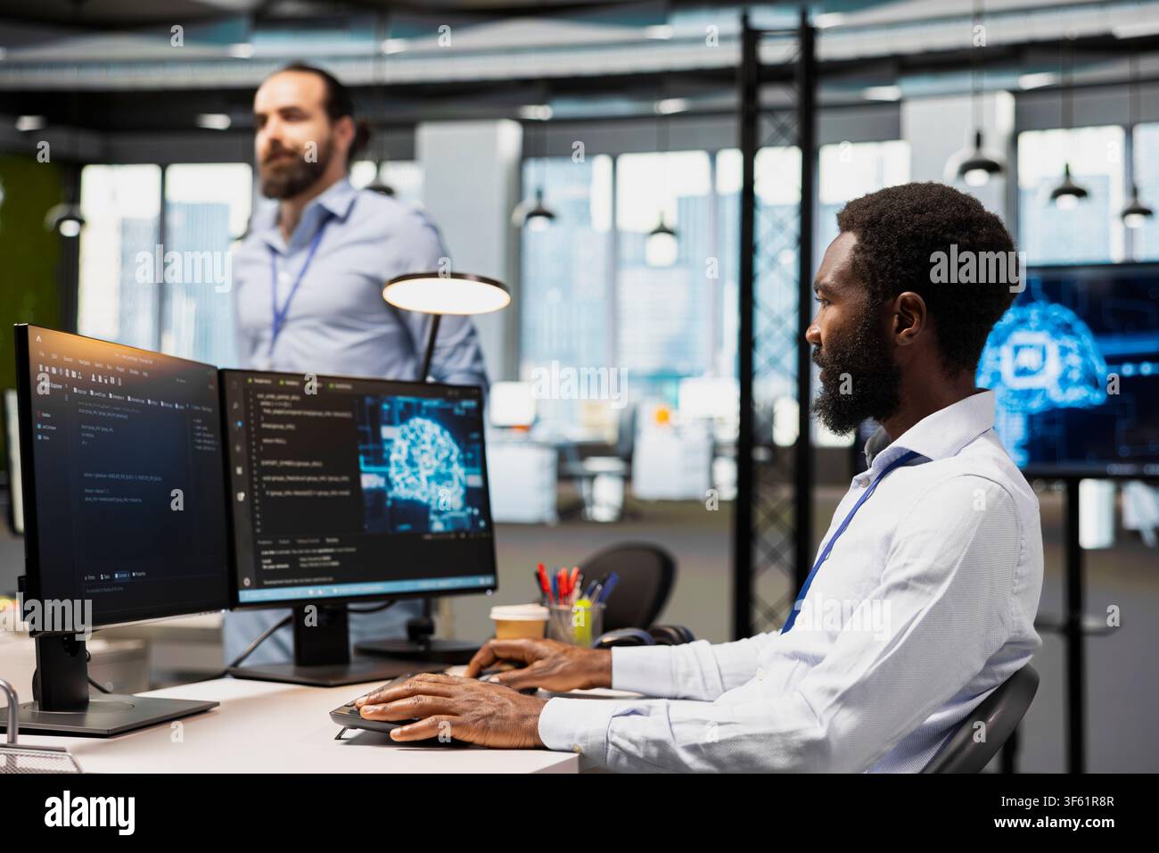 Computer scientist in office using AI automation scripts to reduce repetitive coding tasks. African american man using artificial intelligence technology in startup workspace Stock Photo