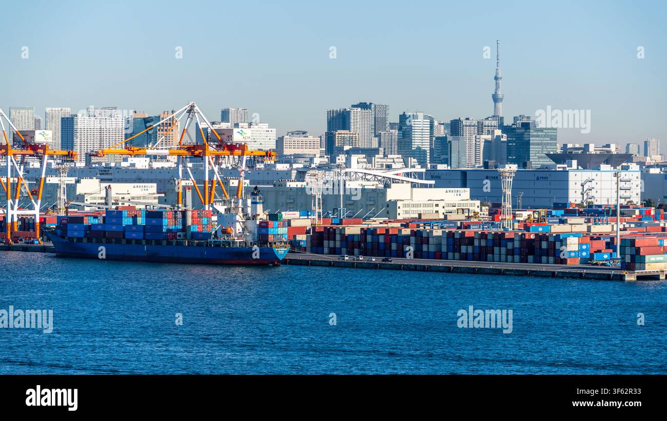 Tokyo Japan , 24 January 2026 : Tokyo port view with container ship and containers on dock with cranes and skyline with Skytree in Tokyo Japan Stock Photo